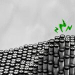 A bunch of black and white objects with a green arrow above them